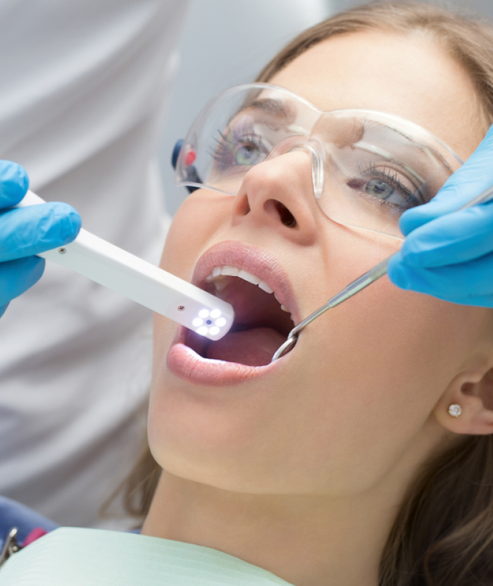 Image of a lady patient being undergone a dental treatment