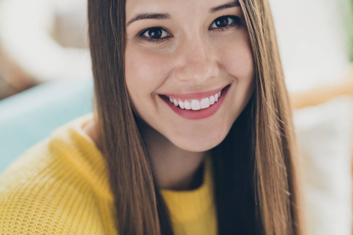 Cropped close up portrait of young lady smiling.